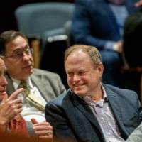 2 guests in the audience smile, enjoying their time